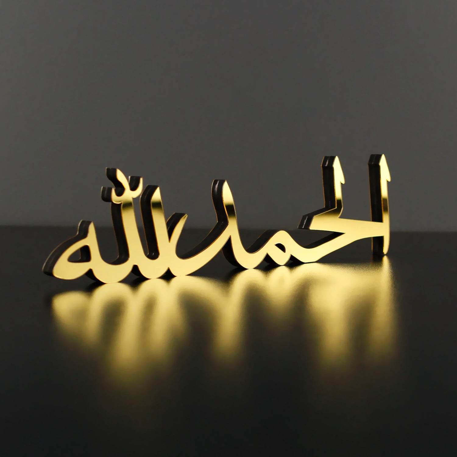 Gold Arabic calligraphy decor on black surface, Islamic wall art, modern Islamic home decor